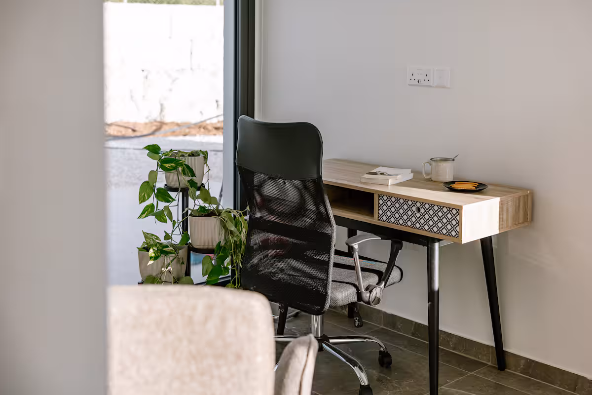 Dedicated workspace with a wooden desk and office chair next to a window