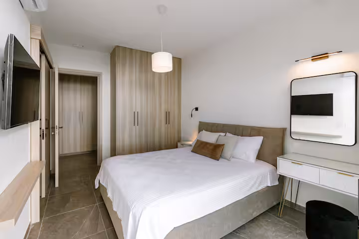 Bedroom with a double bed, TV and dressing table